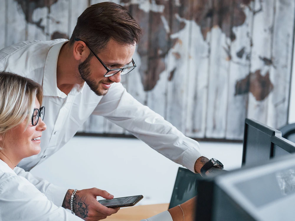 IT-Mitarbeitende der SALK bei der Arbeit an mehreren Monitoren im Technikbüro – Karriere in der Informationstechnologie im Gesundheitswesen